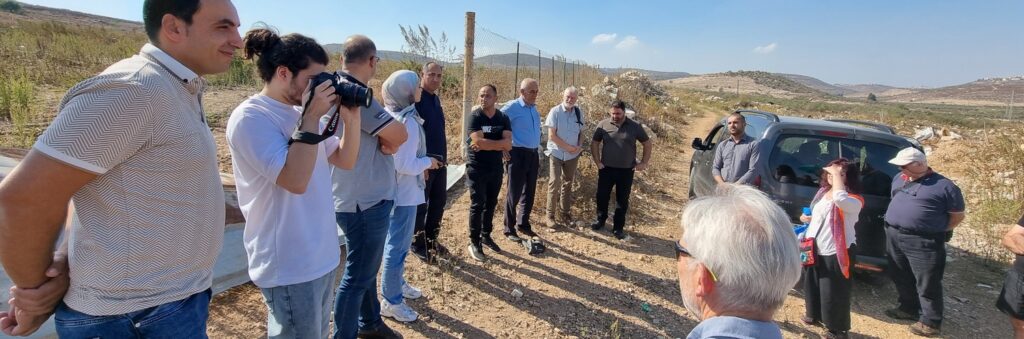 People in a line at a gate into a field